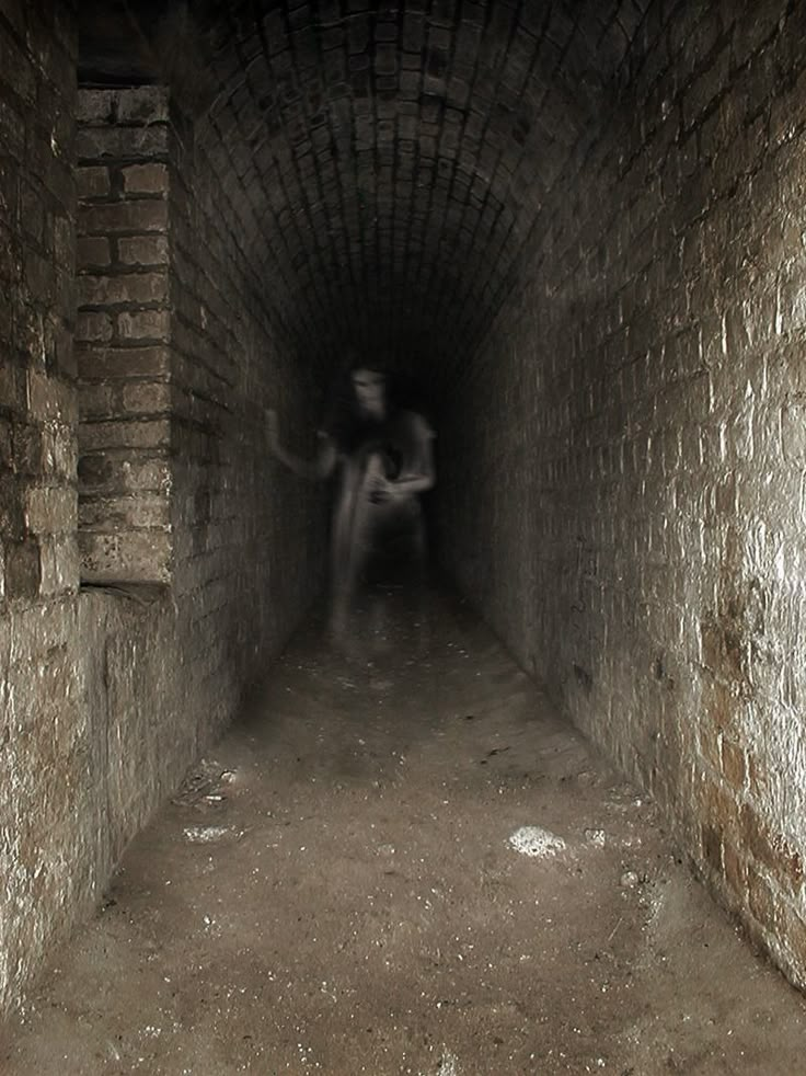 a person sitting in the middle of a dark tunnel