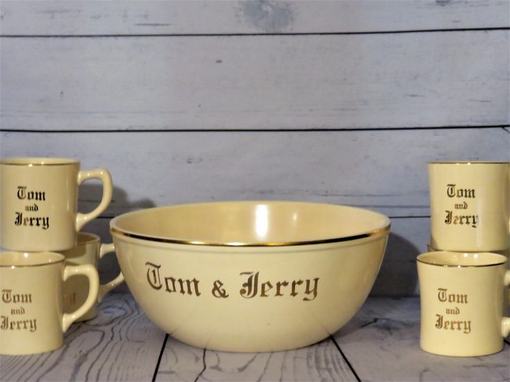 a set of four coffee mugs and cups with the words tun & jerry printed on them