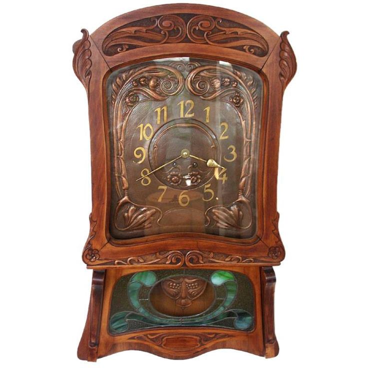 an old wooden clock with ornate carvings on the front and sides, sitting against a white background