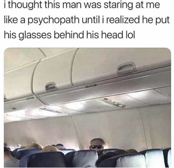 the inside of an airplane with people sitting in seats and one person standing on the aisle