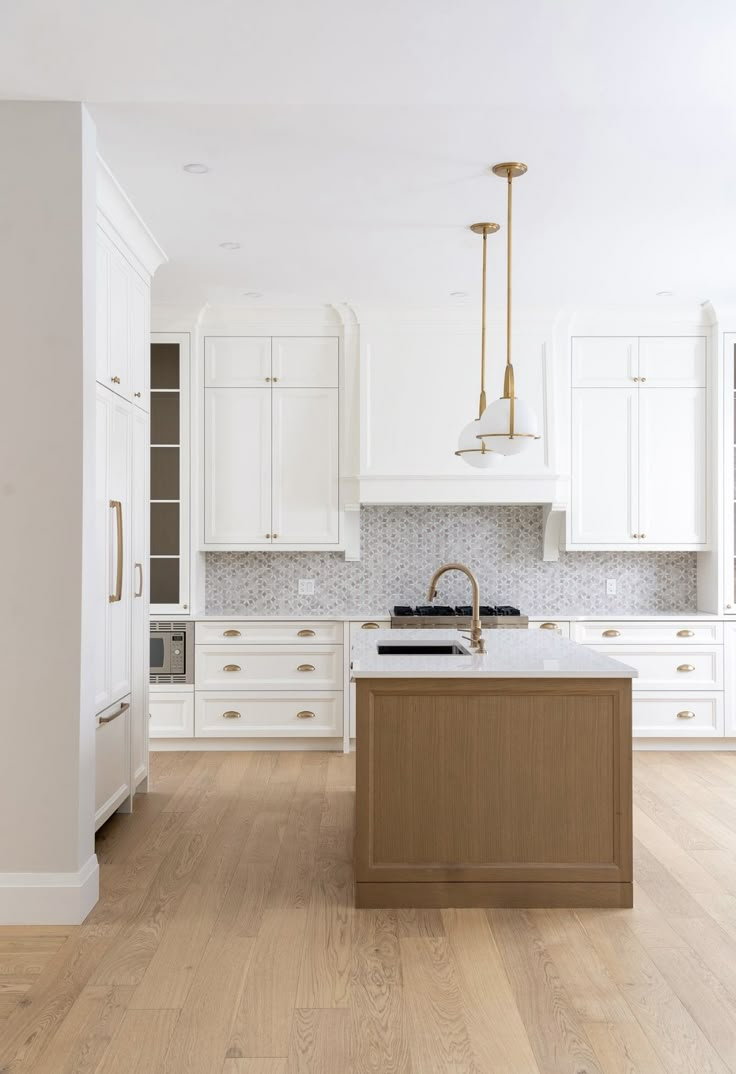 an empty kitchen with white cabinets and wood flooring is pictured in this image from the front view