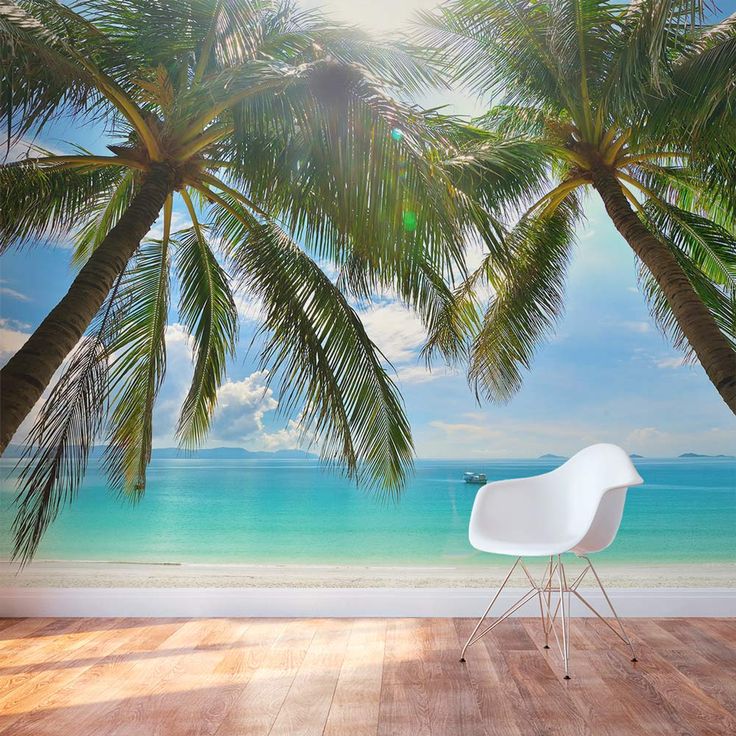 a chair sitting on top of a wooden floor next to palm trees and the ocean