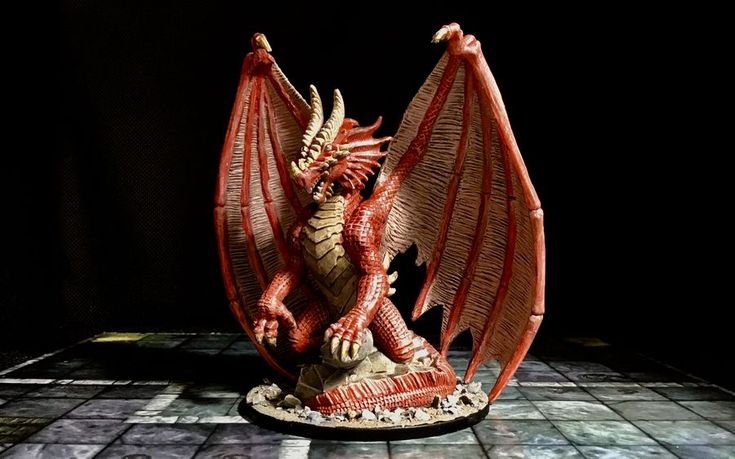 a red dragon figurine sitting on top of a tiled floor in front of a black background