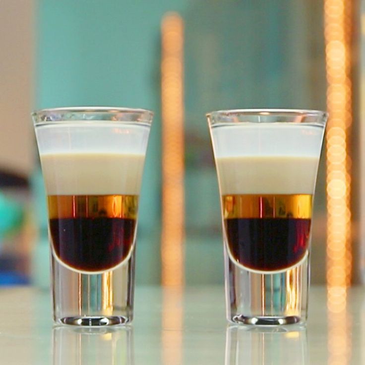 two shot glasses filled with liquid sitting on a counter