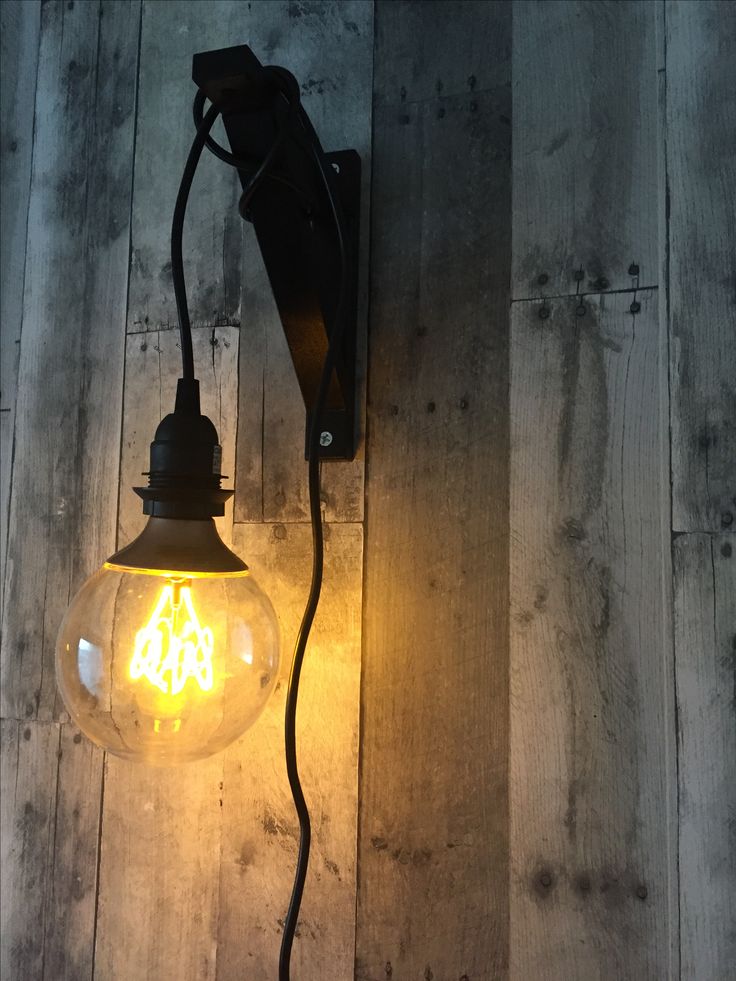 an old fashioned light bulb on a wooden wall