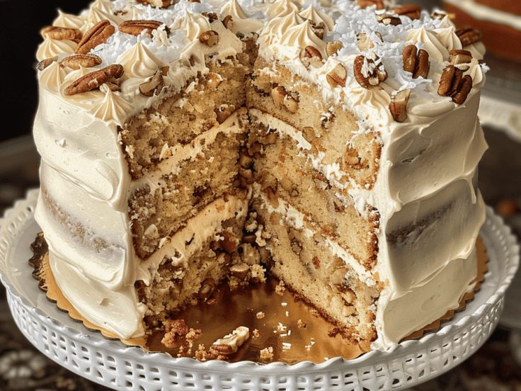 there is a large cake with white frosting and pecans on the top layer