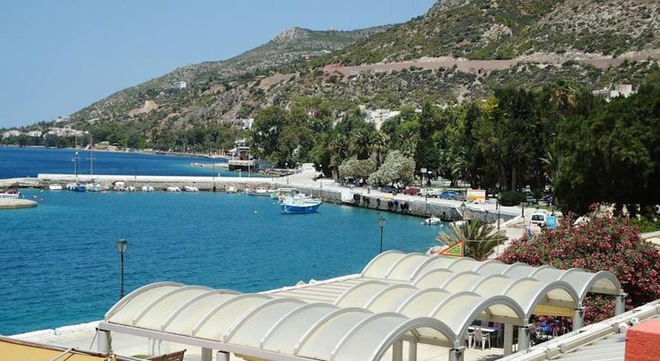 the water is blue and clear with boats docked in it's dock area next to some hills