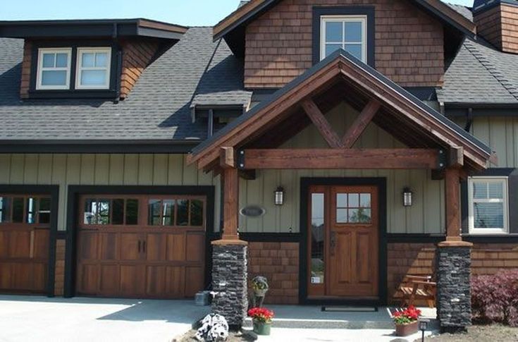 a large brown house with two garage doors