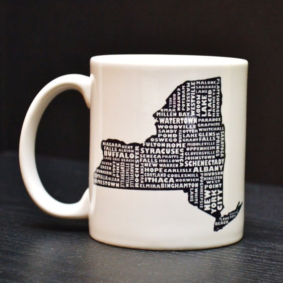 a white coffee mug with the shape of new york on it