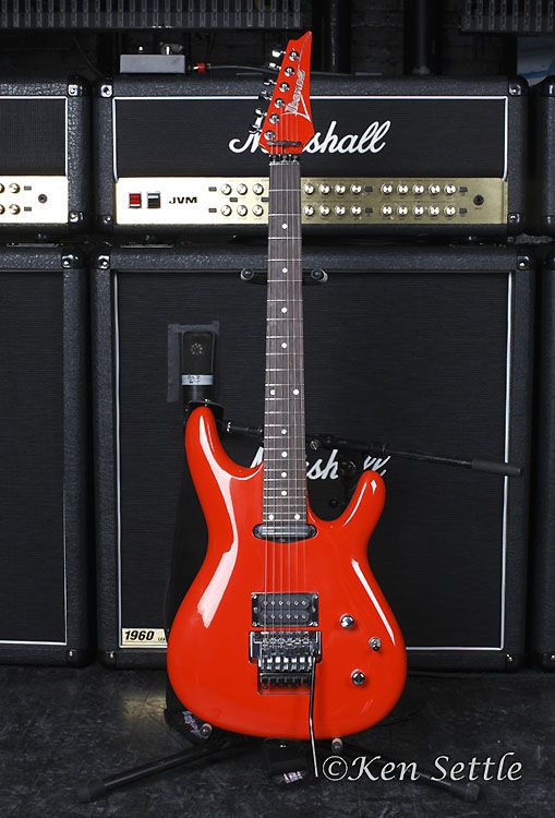 a red electric guitar sitting on top of a table