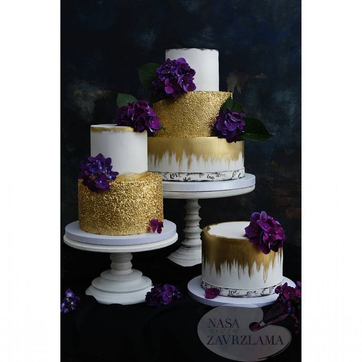 three tiered cakes with gold and white frosting, purple flowers on each one