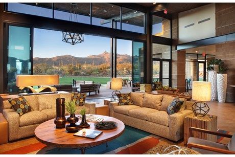 a living room filled with lots of furniture and large windows overlooking the mountains in the distance