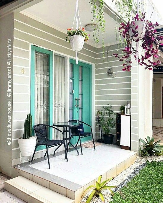 an outdoor patio with chairs, table and potted plants on the side walk way