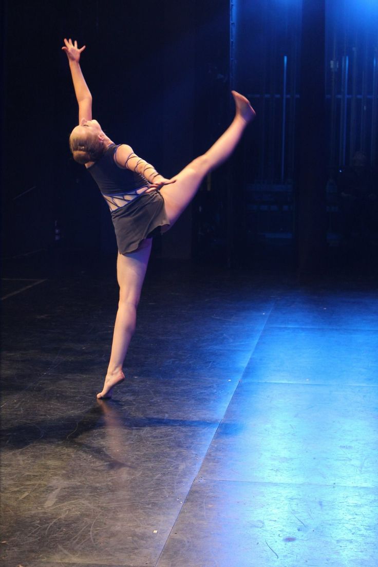 a woman is performing on stage with one leg in the air