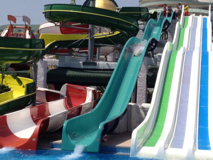 several water slides are lined up in the pool