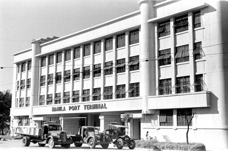 an old black and white photo of a building with cars parked in front of it