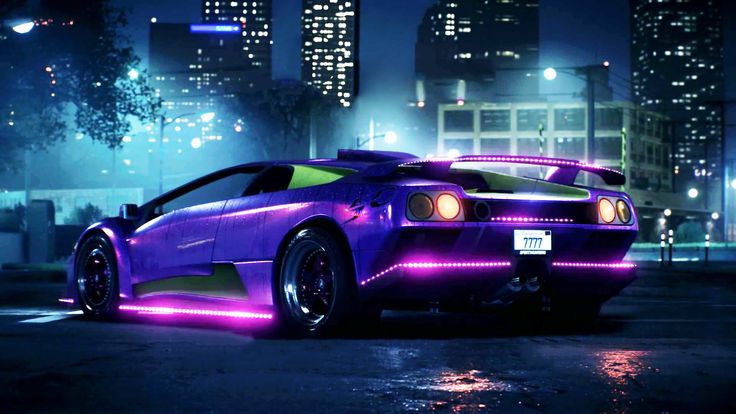 a purple sports car parked in the middle of a city at night with lights on