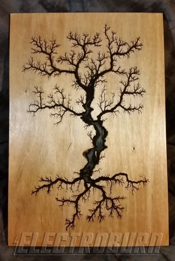 a tree with no leaves is shown on a wooden plaque that has been carved into it