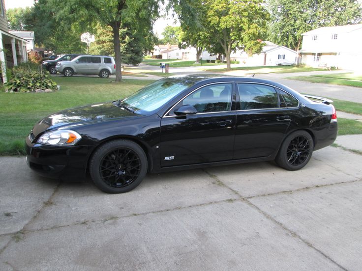 a black car is parked on the sidewalk