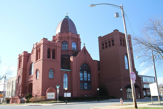 a large red building sitting on the side of a road next to a traffic light