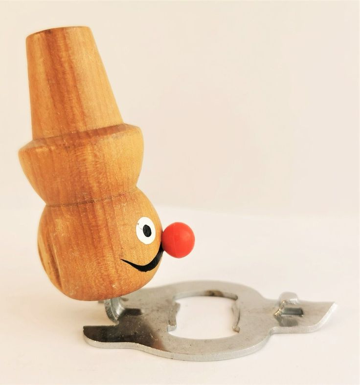 a wooden toy with eyes and nose standing next to a wrench