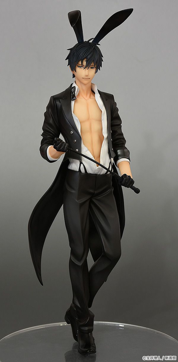 an action figure is posed on a round base, wearing a black suit and white shirt