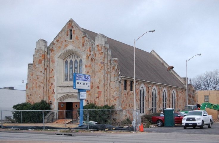 an old church with cars parked in front