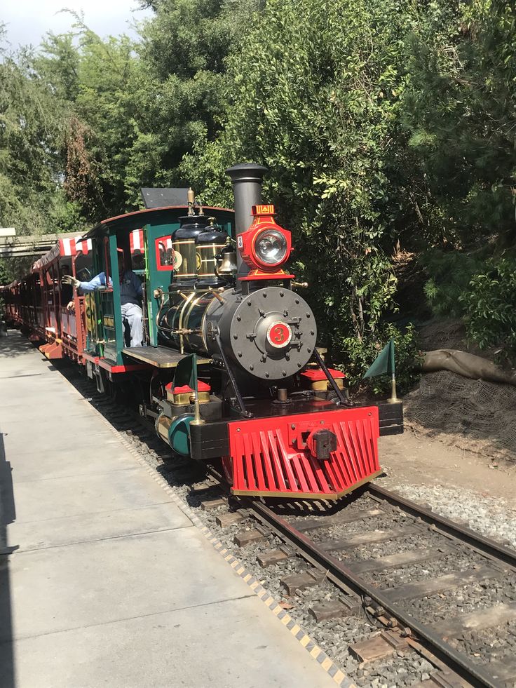 an old fashioned train is parked on the tracks