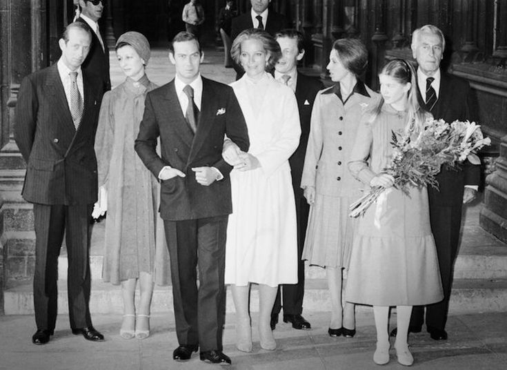 an old black and white photo of people standing on steps with flowers in their hands