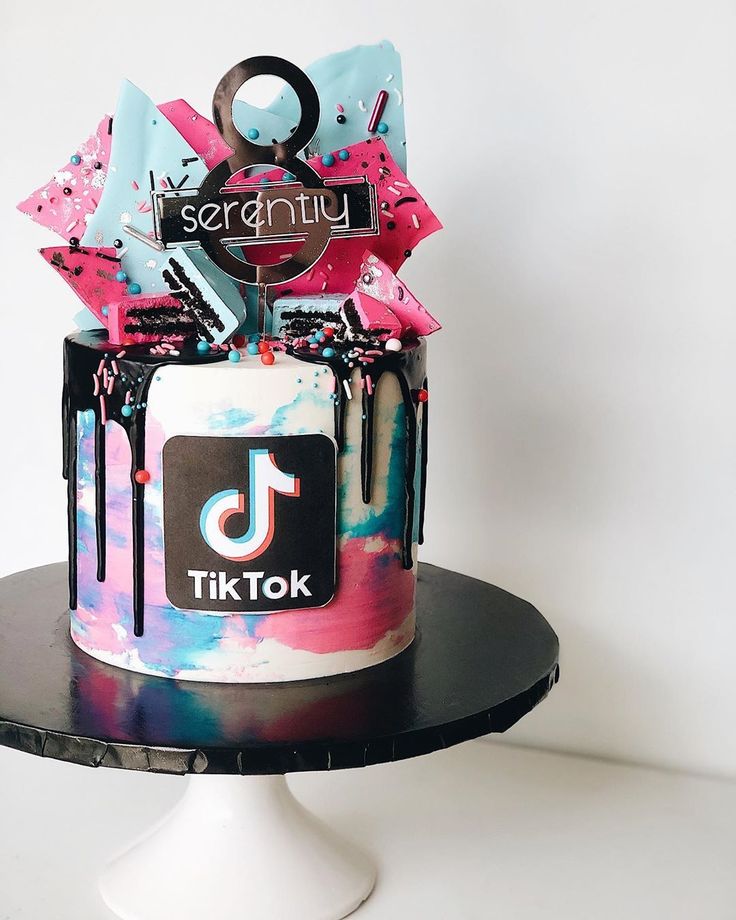 there is a colorful cake on top of a black plate with scissors and other decorations