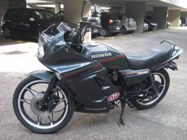 a black motorcycle parked in front of a parking garage