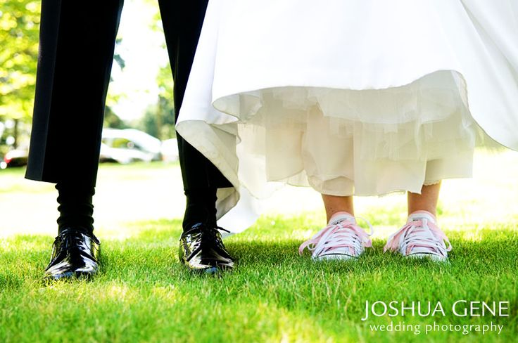 two people standing in the grass with their feet on each other's butts