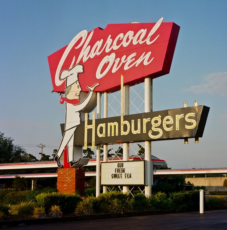 a large sign for a restaurant called charcoal oven hamburgers