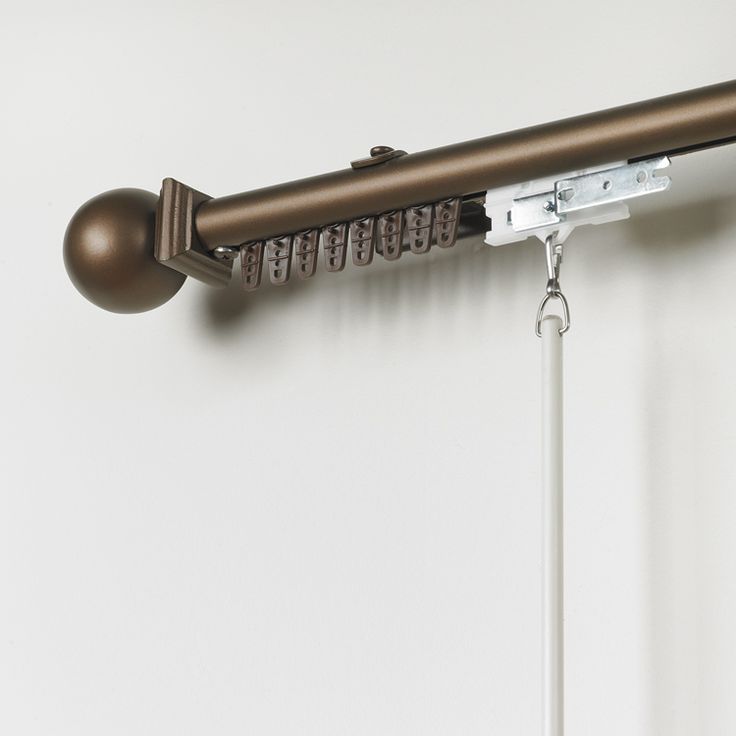 a close up of a curtain rod on a white wall