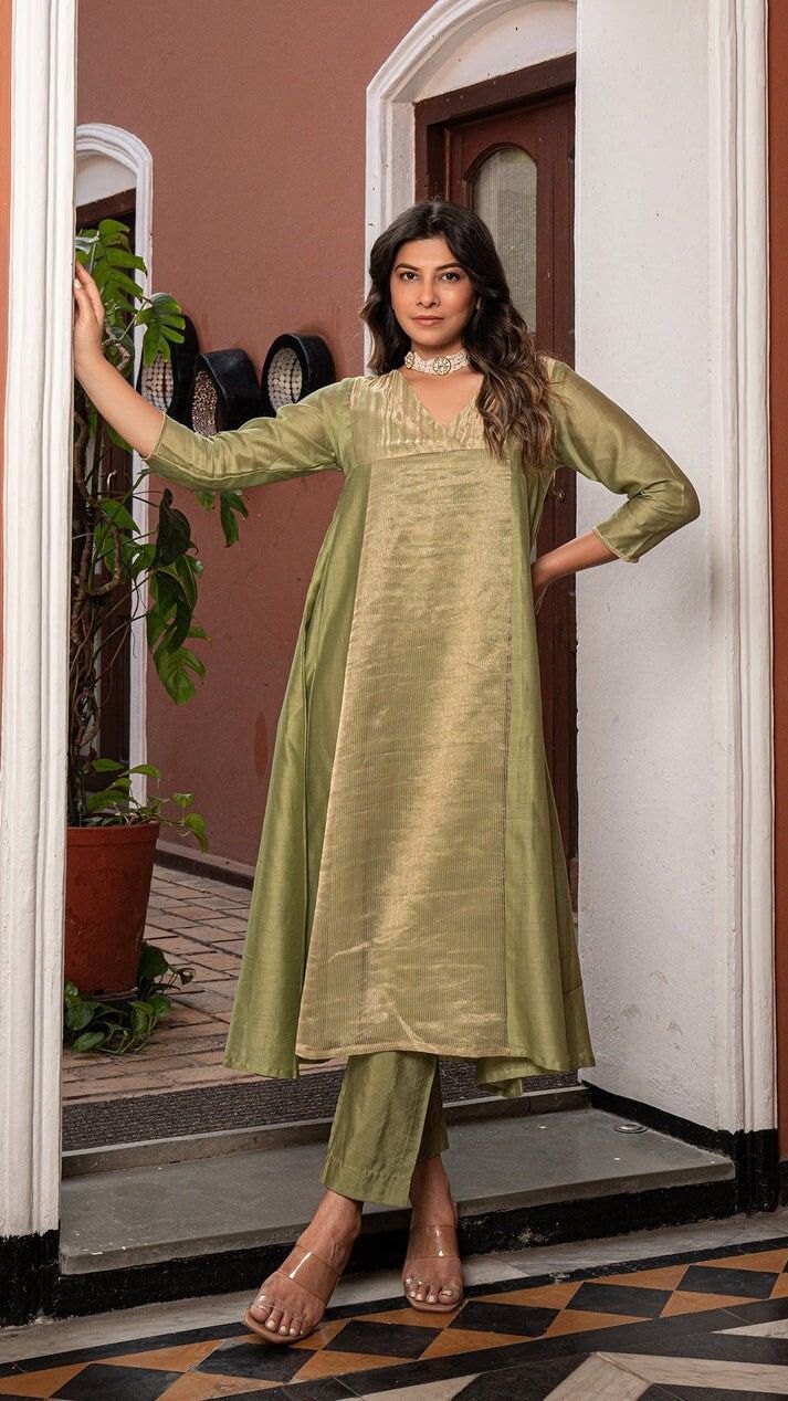 Green Golden Tissue Chanderi Anarkali Kurta Set, Kurta pant set Anarkali dresses, Indian wedding outfit Bring on the festive spirit with our anarkali kurta set in pure tissue and chanderi silk. Panelled Anarkali Kurta with separate inner and matching cotton silk pants. Kurta Fabric : Pure Tissue + Chanderi Silk. Pants : Cotton Silk. Dupatta : Pure Tissue. Colour : Light Green. Model height is 5.6" and is wearing a size S. Wash Care : Dry Clean Only. This product will be exclusively handcrafted f Festive Tissue Silk Palazzo Set For Diwali, Pista Green Chanderi Anarkali Set With Pallu, Bollywood Style Slub Silk Churidar With Dabka, Straight Tussar Silk Kurta With Sheer Dupatta, Festival Tissue Silk Straight Kurta, Pista Green Slub Silk Churidar For Festivals, Pista Green Chanderi Floor-length Kurta, Unstitched Raw Silk Anarkali Set For Navratri, Pista Green Floor-length Chanderi Kurta