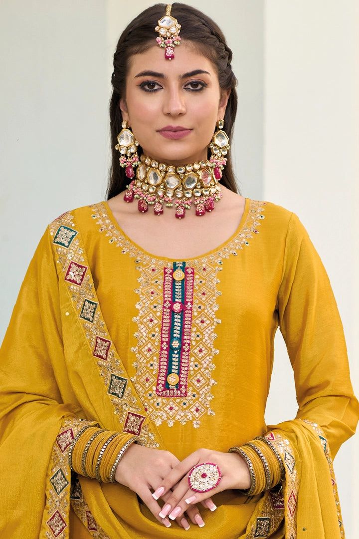 This Mustard color Party Wear Palazzo Salwar Suit flaunts sophistication with zari, resham, badla, and sequence work along the kameez. Accented by a baluming chinnon silk embroidered palazzo bottom, santoon lining, and sequence embroidered baluming chinon silk dupatta, this ensemble is perfect for weddings and other special events. Final sale Kameez baluming chinon silk with heavy embroidery & sequin work Sharara baluming chinon silk with heavy embroidery front and back Dupatta baluming chinon s Festive Kurta With Mirror Work In Slub Silk, Festive Slub Silk Kurta With Mirror Work, Designer Slub Silk Sets With Mirror Work, Mirror Work Slub Silk Sets, Festival Slub Silk Churidar With Mirror Work, Festivals Slub Silk Churidar With Mirror Work, Semi-stitched Slub Silk Salwar Kameez With Mirror Work, Gold Slub Silk Palazzo Set With Dabka Work, Gold Palazzo Set With Dabka Work In Slub Silk