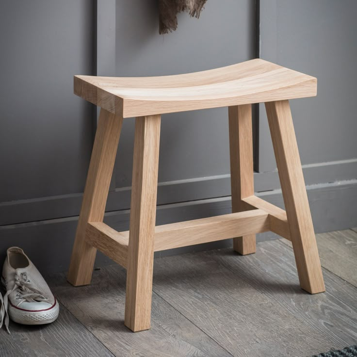 a wooden stool next to a pair of shoes