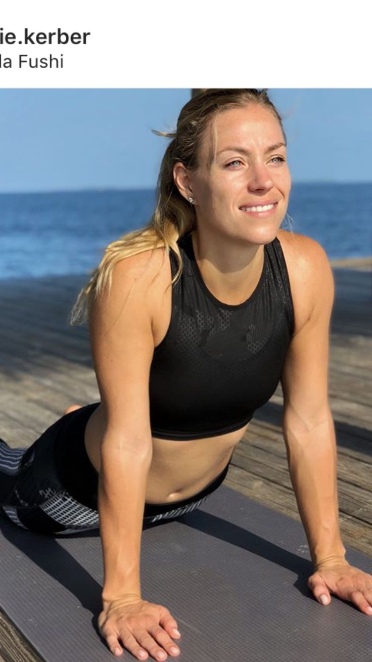 a woman is doing yoga on the beach