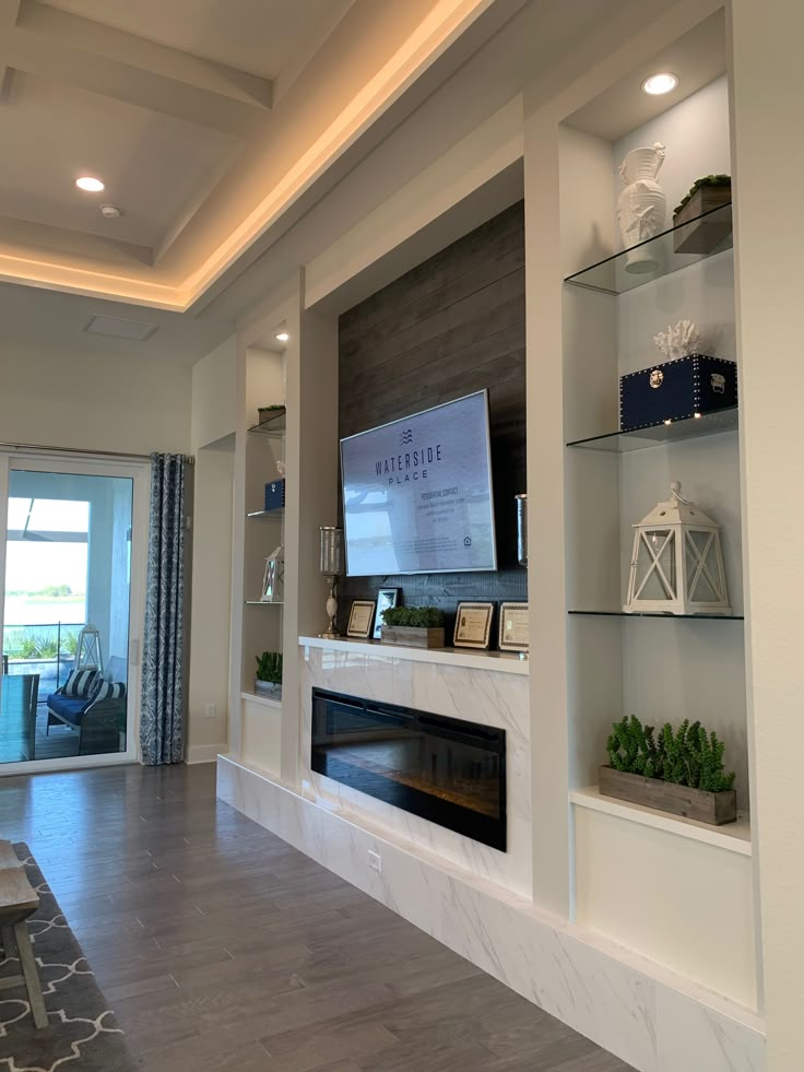 a living room with a fireplace and tv mounted on the wall above it's mantle