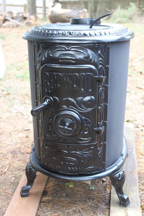 an old fashioned stove sitting on top of a wooden platform