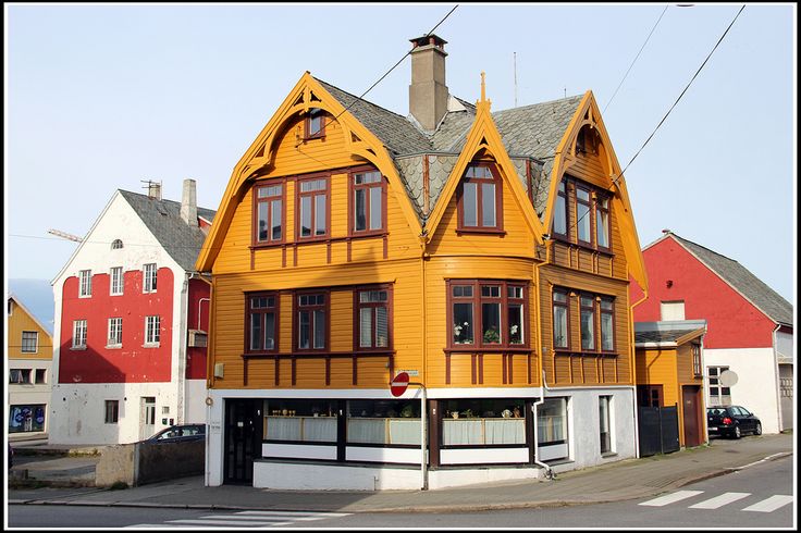 a large yellow house with two storys on the top floor and three stories down the middle