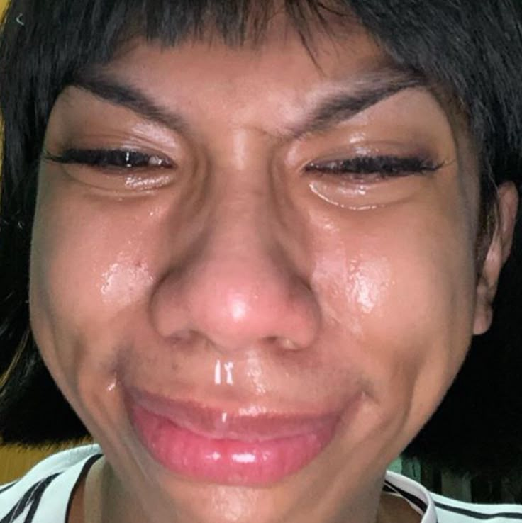 a close up of a person with tears on their face and eyes, looking at the camera