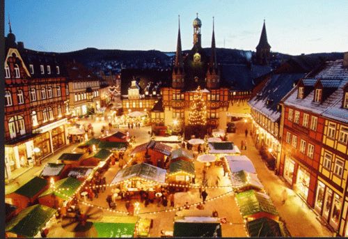 an aerial view of a christmas market at dusk