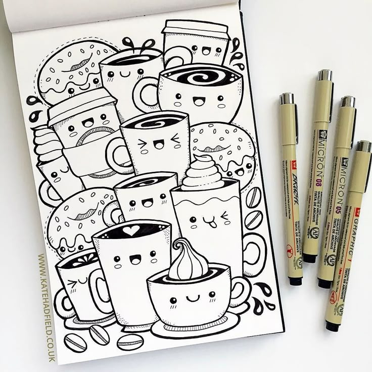 a notebook with coffee cups and donuts drawn on it next to markers, pens and pencils