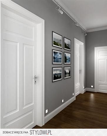 an empty room with white doors and pictures on the wall