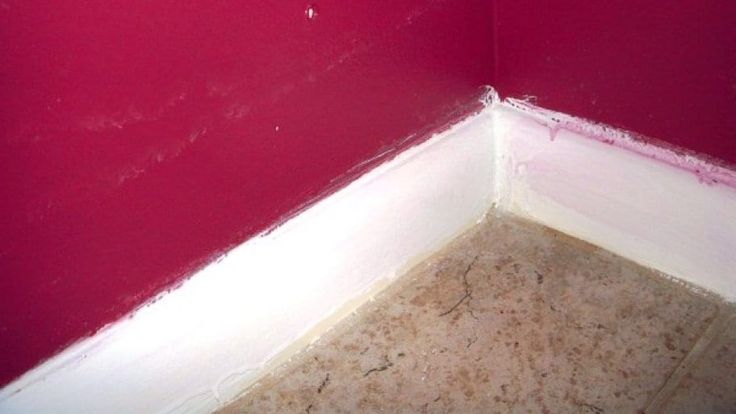 the corner of a room with red walls and white trim on it's edges