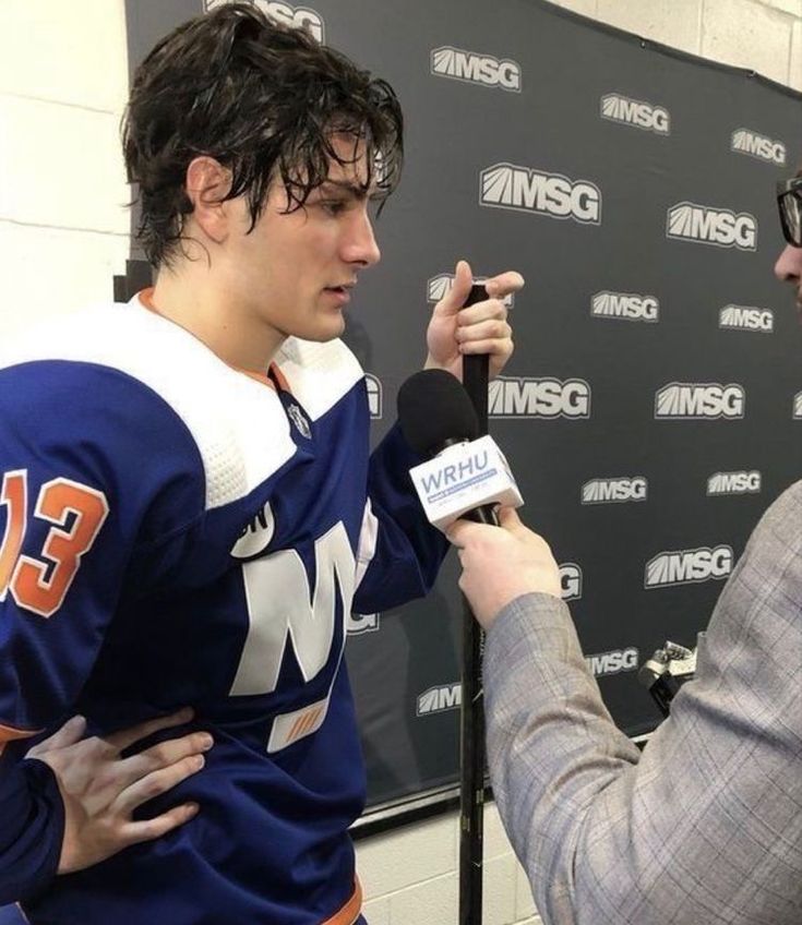 a hockey player is interviewed by an announcer