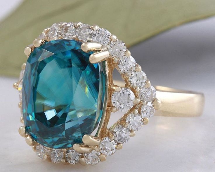 8.70 Carats Natural Very Nice Looking Blue Zircon and Diamond 14K Yellow Gold Ring Suggested Replacement Value: 9,000.00 Total Natural Cushion Shaped Zircon Weights: Approx. 7.80 Carats Zircon Measures: 11 x 8.4mm Natural Round Diamonds Weight: .90 Carats (color G-H / Clarity SI1-SI2) Ring total weight: 5.2 grams Disclaimer: all weights, measurements and colors are approximate and may vary slightly from the listed dimensions or as seen in the image. All pictures are magnified to show the smalles Luxury Blue Topaz Ring Gia Certified, Blue Gia Certified Emerald Ring For Formal Occasions, Elegant Blue Emerald Ring With Prong Setting, Luxury Blue Moissanite Rings, Formal Blue Topaz Ring With Moissanite, Blue Emerald Halo Setting Ring, Elegant Blue Emerald Ring With Brilliant Cut, Blue Emerald Rings With Halo Setting, Blue Emerald Ring With Round Cut