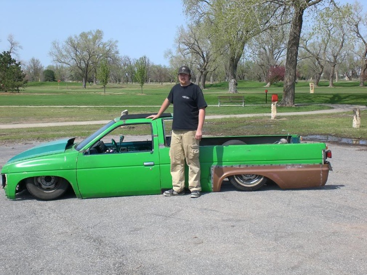 a man standing next to a green pick up truck