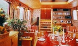 the inside of a restaurant with red table cloths and yellow chairs, wooden walls and ceiling